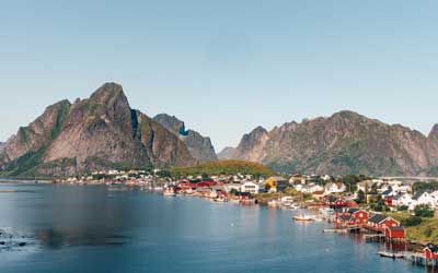 a fishing village with mountains surrounding it